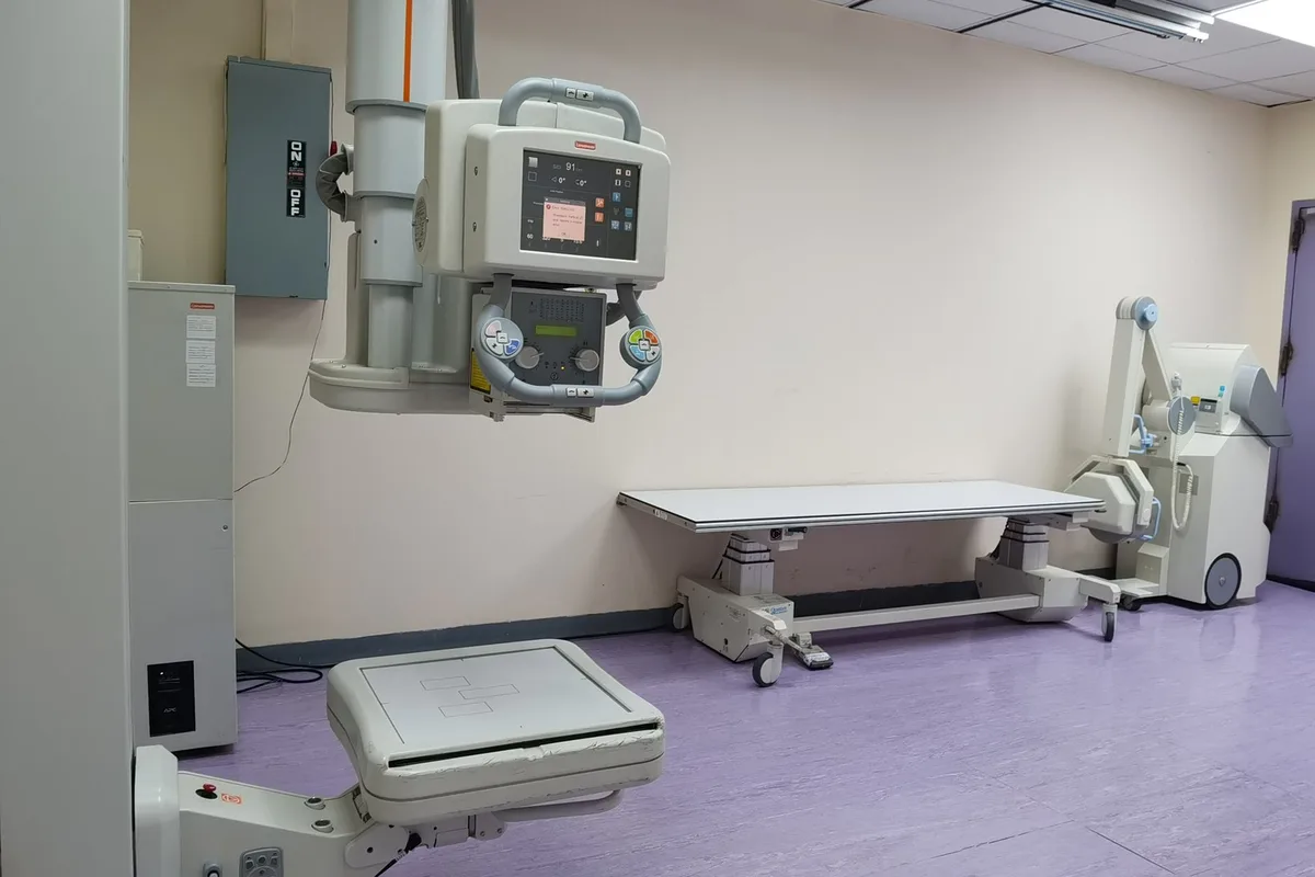 A fluoroscopic C-arm positioned over a procedure table during a guided spinal injection.