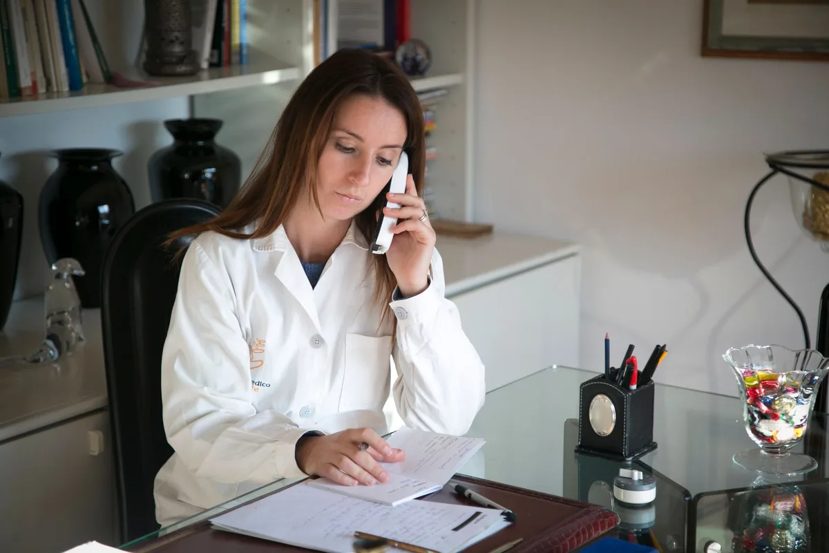 A physician on the phone discussing a patient referral.