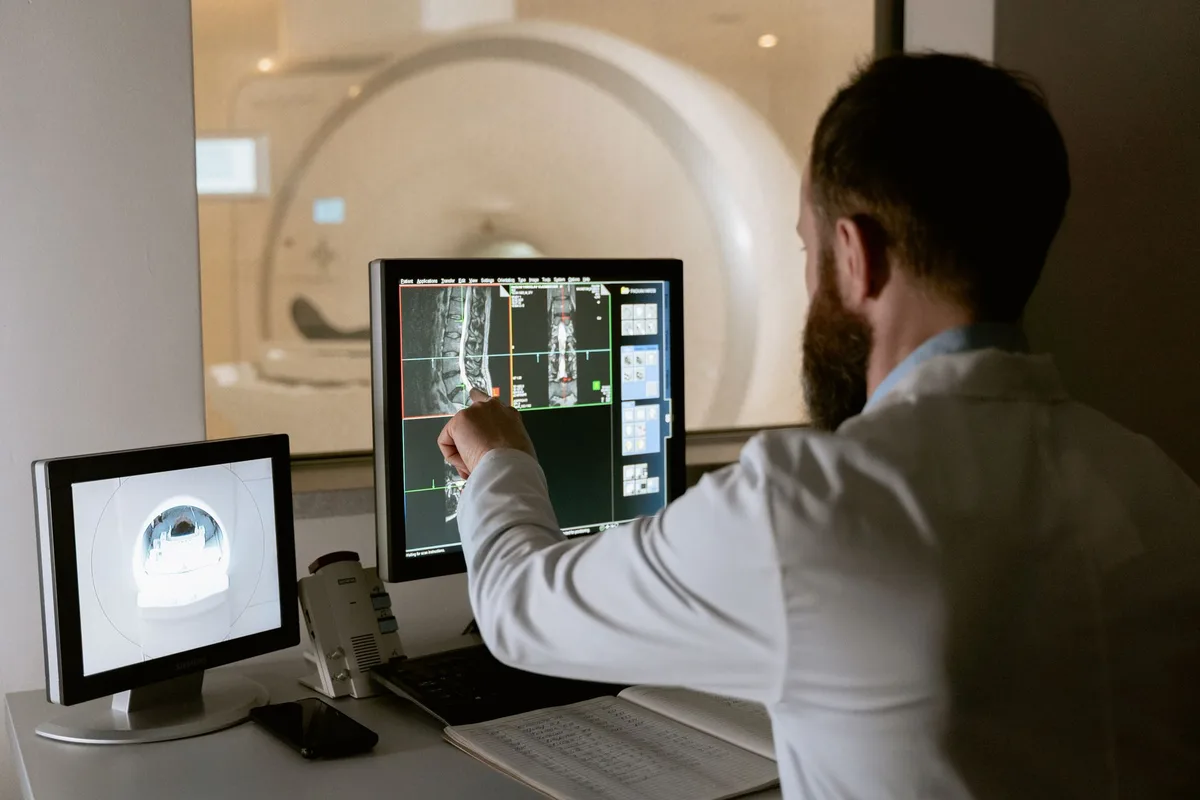 A physician reviewing a lumbar spine MRI showing a disc herniation with the patient.