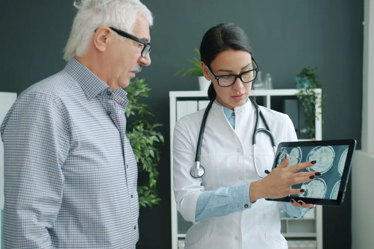 A physician reviewing a spine image with a patient during a consultation.