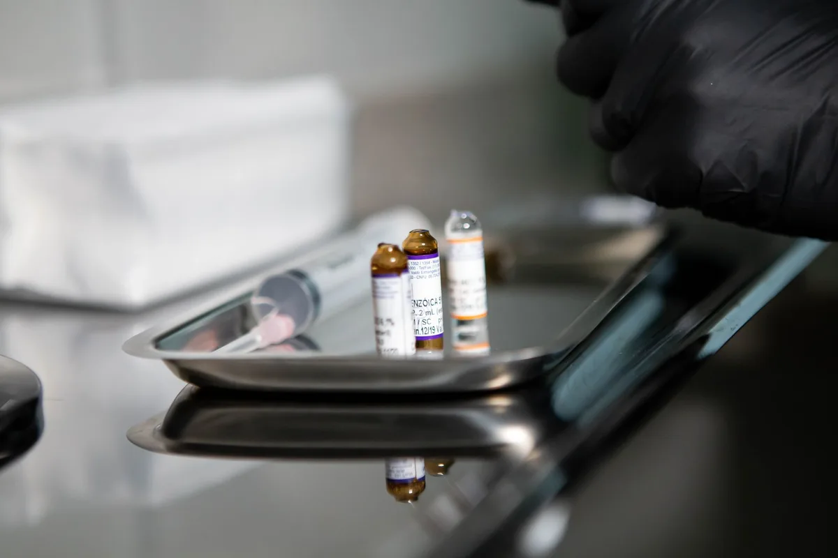 A syringe and medication vial arranged on a clinical procedure tray.