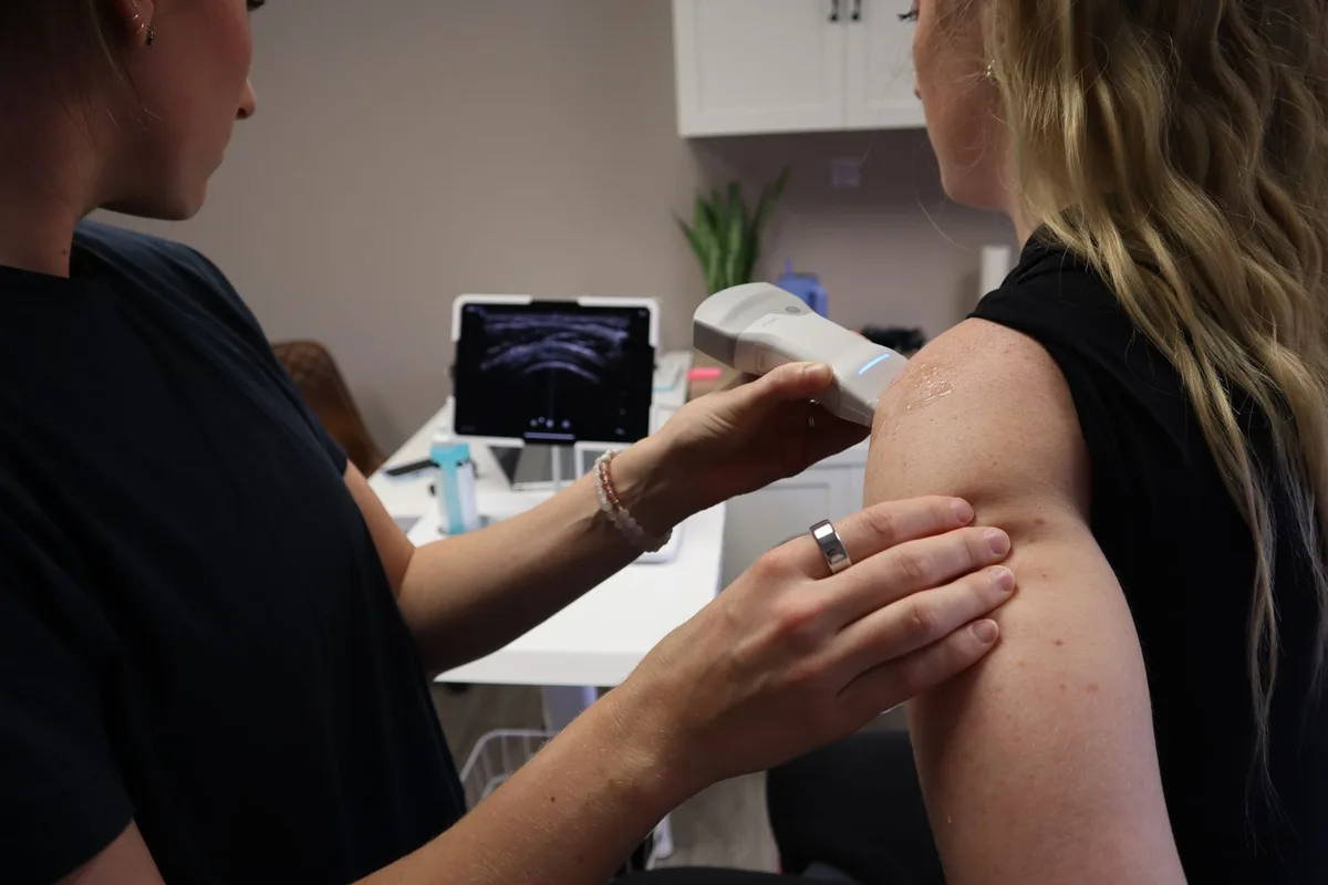 An ultrasound-guided injection being performed at a patient's hip joint.