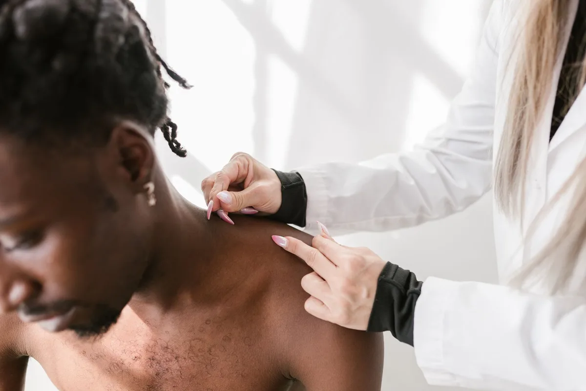 A clinician locating landmarks at the base of the skull before an occipital nerve injection.