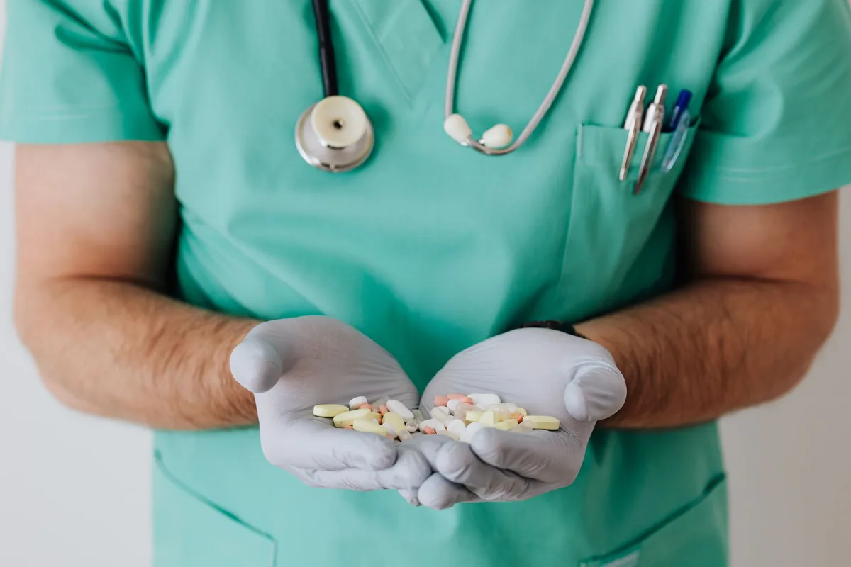 A clinician reviewing a medication regimen in a clinical setting.
