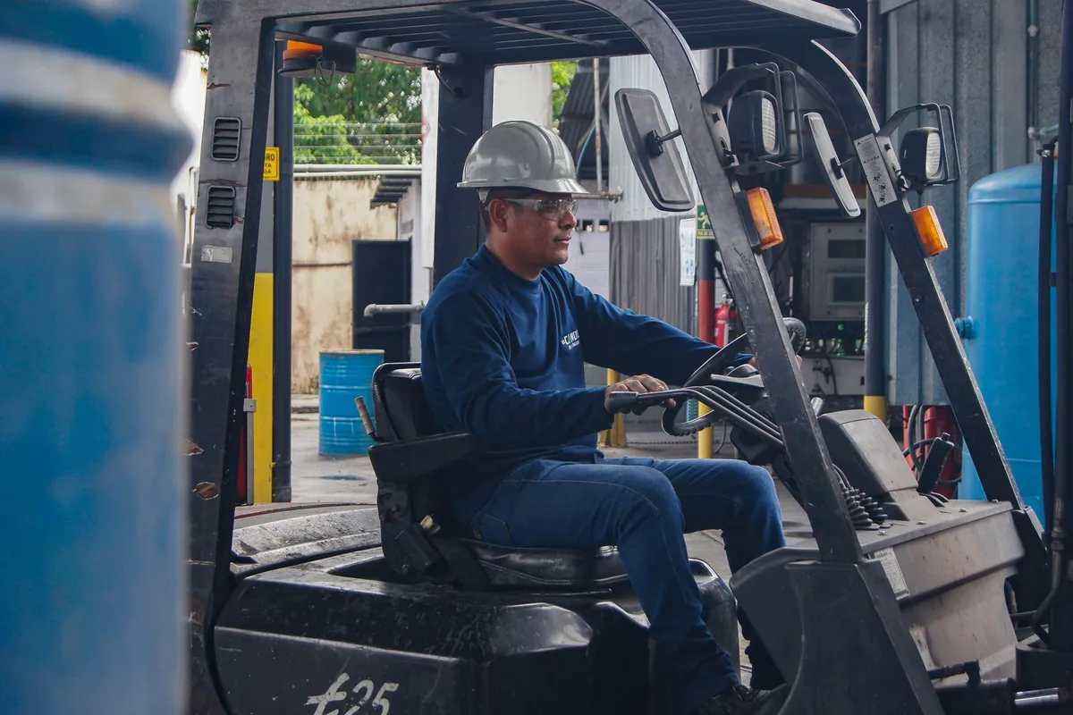 A forklift operator stepping down from the equipment in a distribution warehouse.