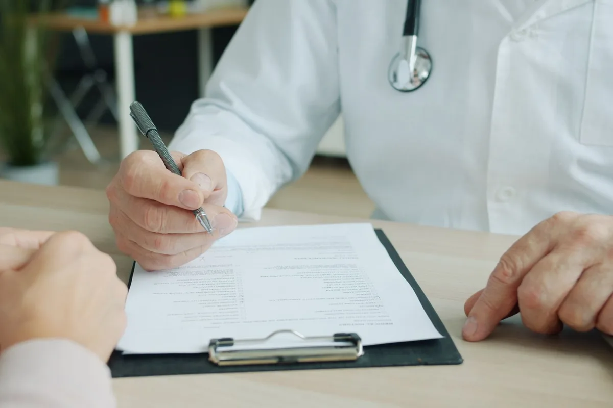 An insurance card placed alongside medical intake paperwork on a clinic desk.