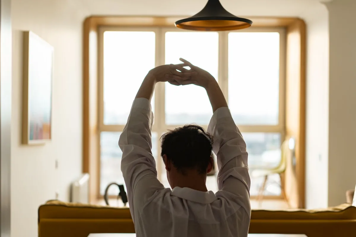 A person doing gentle morning stretches in natural light.