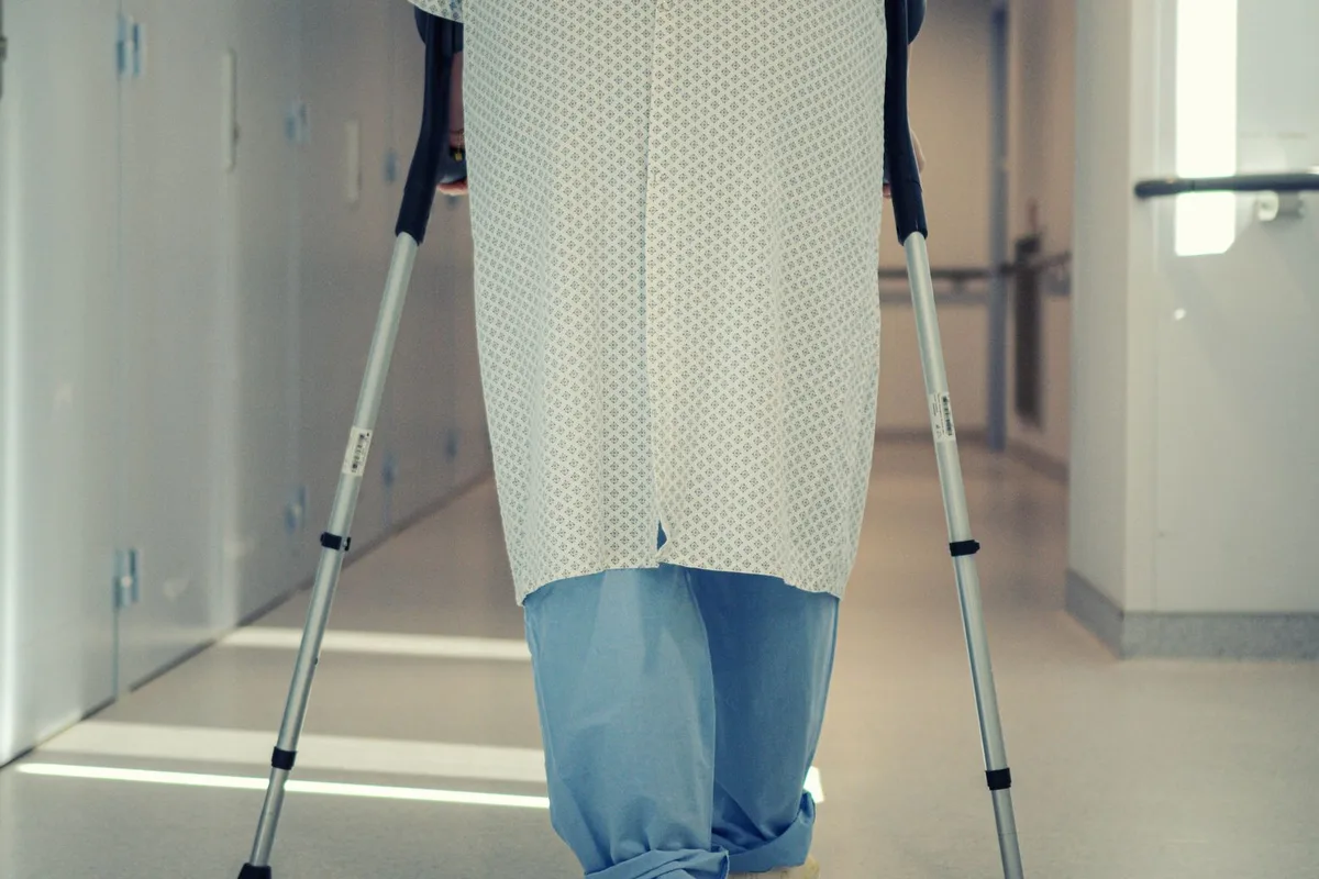 An older patient discussing walking distance and leg pain with a physician.